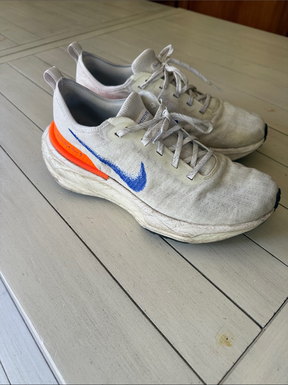 Nike Men’s White Sneakers with Blue Swoosh and Orange Heel Accent